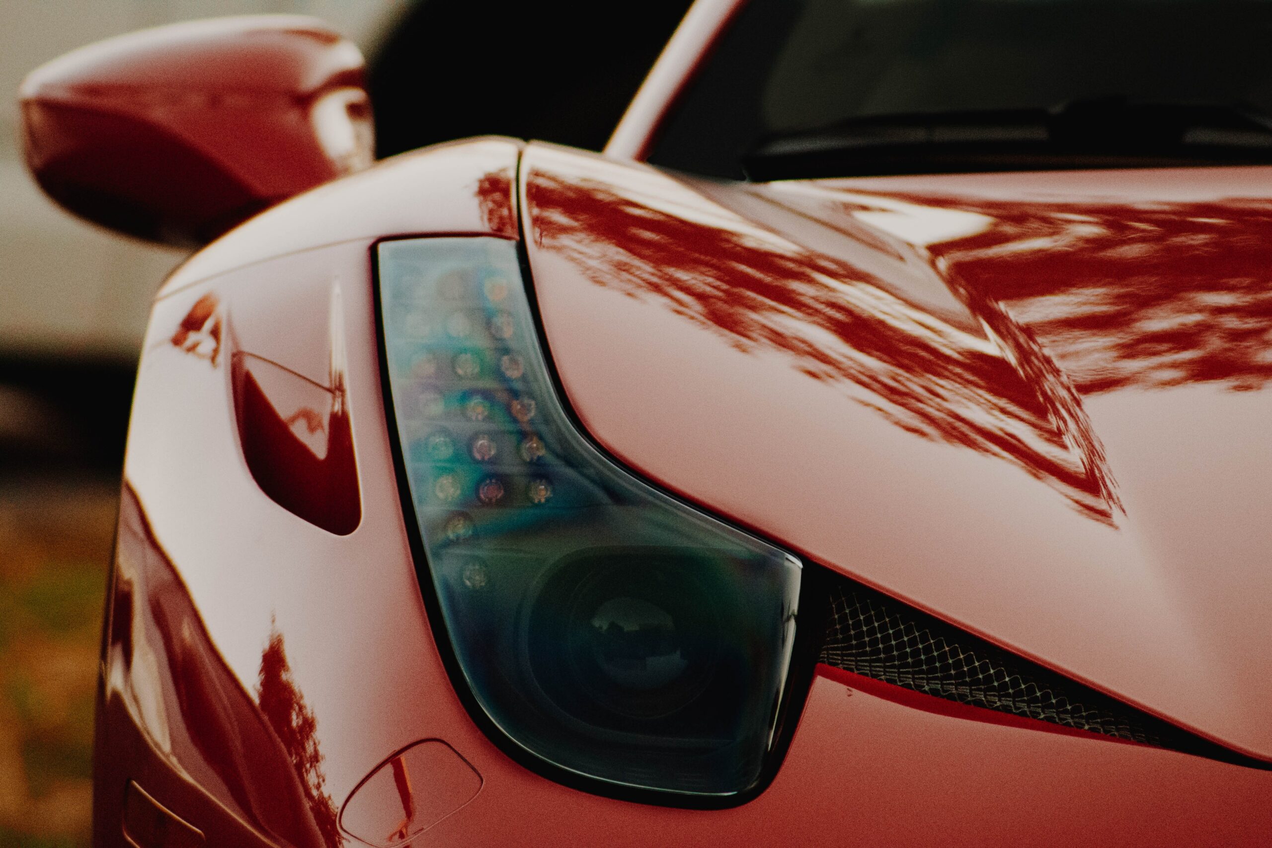 close up of headlight on a red sports car